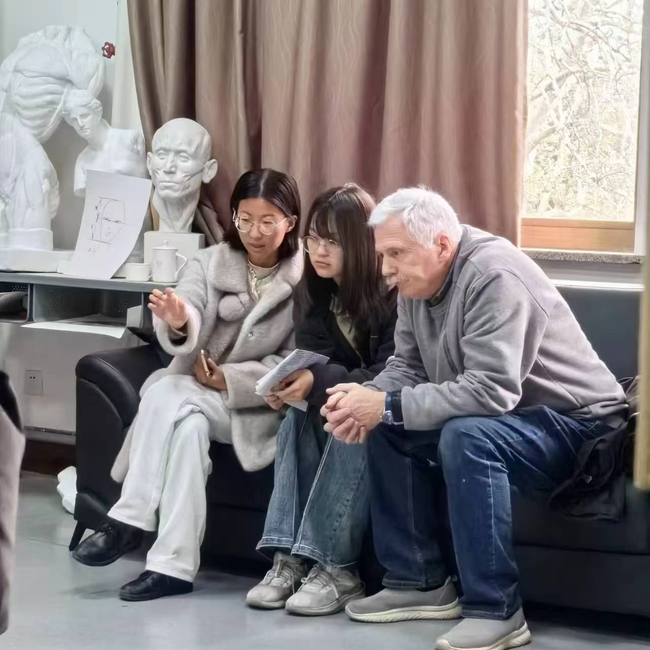 Андрей commenting on a drawing in class