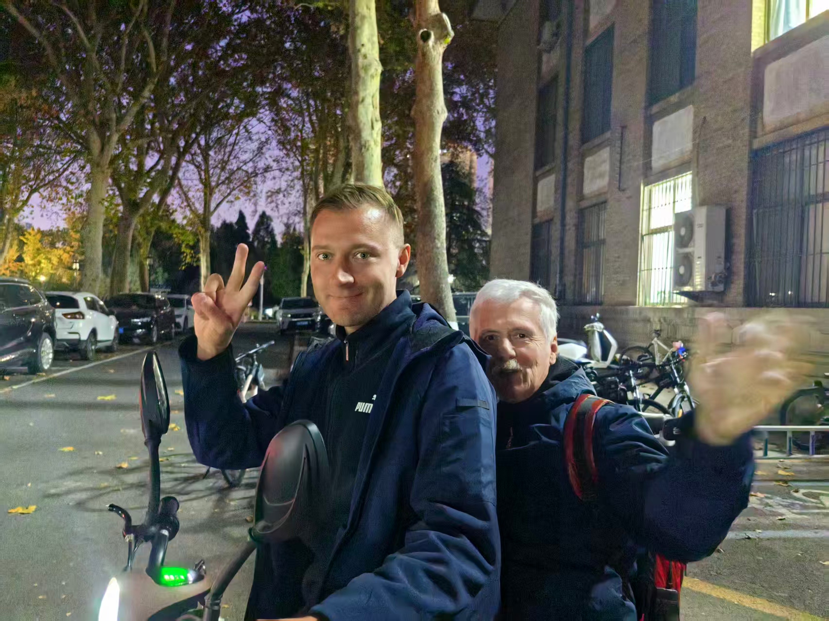 Андрей and Александр riding home on a small electric scooter after work